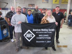 BANNER PRESENTATION JOANNA VINSON (FOUNDER GA. TRADE ) and instructor STEPHEN LEONE holding banner. ONLOOKERS, instructors SCOTT MCNEELY and KYLE LOCKWOOD , DD5 DARYL PETERSON, SECT. CHAIRMAN ROBERT TRUDELLE , sect. secretary RENE ENGERON , sect. social media/ judge CHASE SWEADA .
